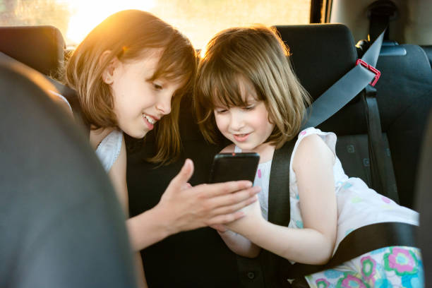 istock Two girls using mobile phone in the car 1502846694