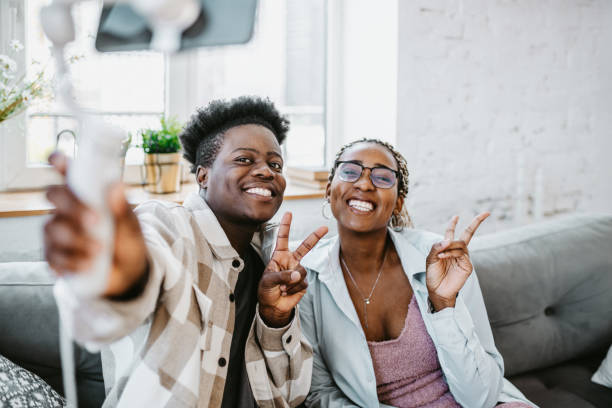 istock Having fun and making selfie. Two black people with a selfie stick smiling at camera 1502847662