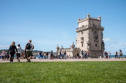 Lisbon, Portugal - May 25 2023: Historical building Torre de Belem in Lisbon with tourists in summer day