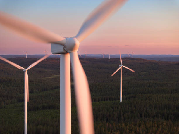 Wind turbines in evening sunlight Wind turbines in a forest landscape in evening sunlight in Dalarna, Sweden. windmill sunset stock pictures, royalty-free photos & images