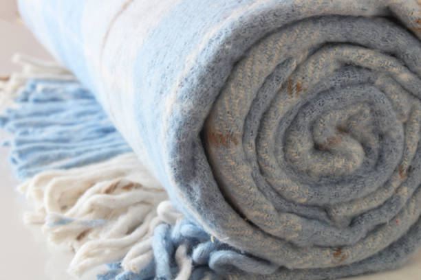 istock Woolen checkered plaid blanket isolated on a white background. White-blue rolled blanket. 1502854228