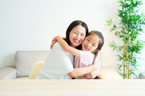 Parent and child hugging with a smile in the room