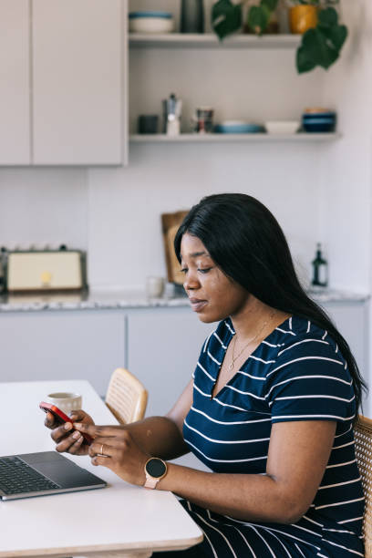istock Young black female freelancer using mobile to securely login to her accounts. 1502857164