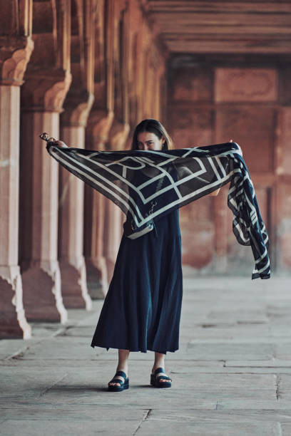 east asian woman in black dress dancing with translucent scarf among columns of ancient temple - taj mahal mahal door temple imagens e fotografias de stock