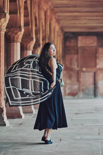 donna dell'asia orientale in vestito nero che danza con sciarpa traslucida tra le colonne del tempio antico - taj mahal mahal door temple foto e immagini stock