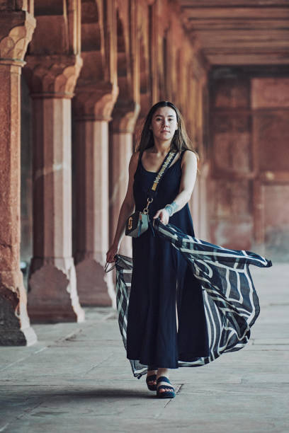 donna dell'asia orientale in vestito nero che danza con sciarpa traslucida tra le colonne del tempio antico - taj mahal mahal door temple foto e immagini stock