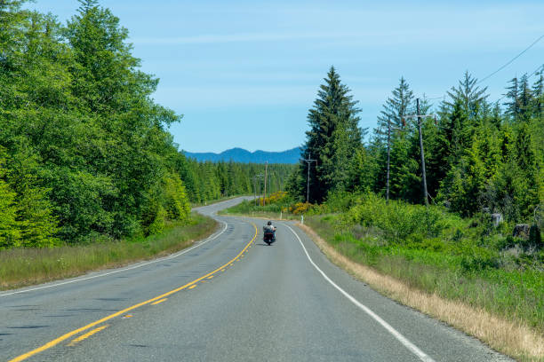 istock Motorcycle on two lane road in mountainous and forested landscape 1502865787