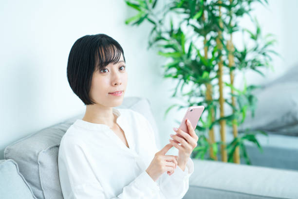 istock Woman sitting on sofa and using smartphone 1502869205