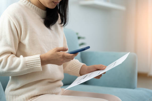 istock woman use phone scan barcode or QR codes to pay credit card bill after receiving document invoice. payment, receive, paying electricity, digital payments, technology, scanning, financial transactions 1502870115