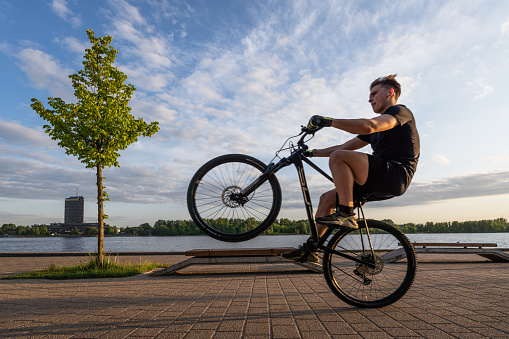 Riga, Latvia - June 15, 2023: A cyclist rides on the bank of the Daugava river