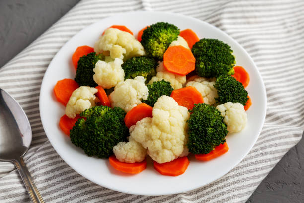 istock Mixed Organic Steamed Vegetables (Carrots, Broccoli and Cauliflower) on a Plate on a gray surface, side view. 1502871519
