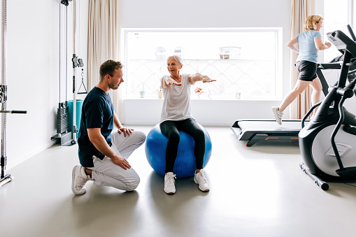 Las personas en una clínica de fisioterapia hacen gimnasia correctiva con el especialista photo