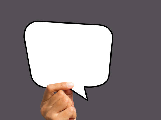 istock Hand holding of an empty white speech bubble against a gray background 1502873544