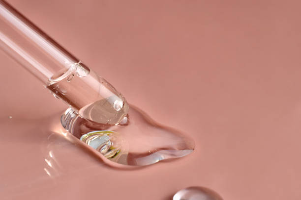 istock Facial serum or oil dripping from a pipette on a pink background. 1502873655