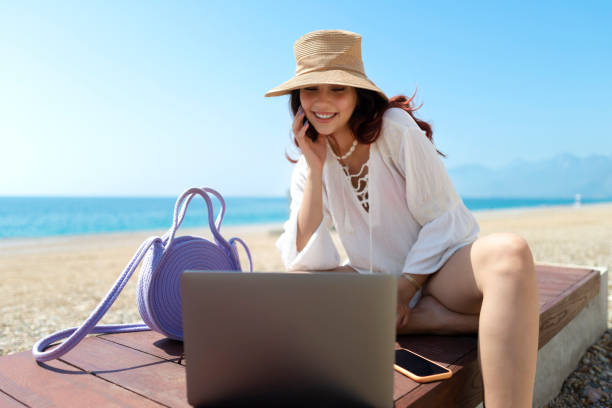 istock Girl using laptop on the beach. 1502875794