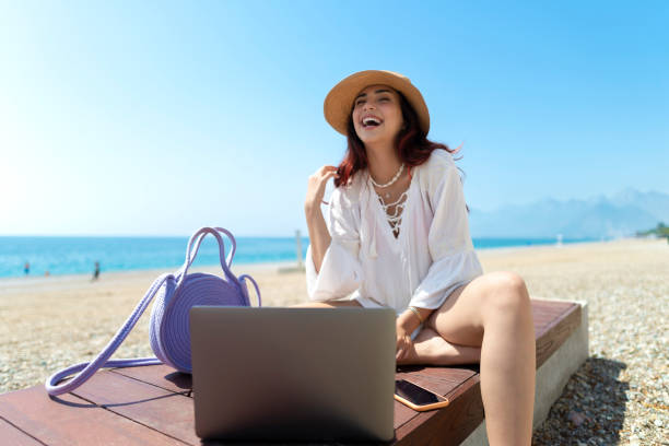 istock Girl using laptop on the beach. 1502875861