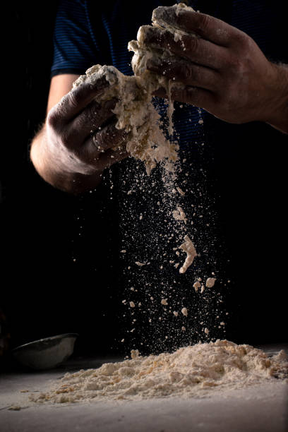 istock Male hands knead pizza dough on a dark background. 1502876024