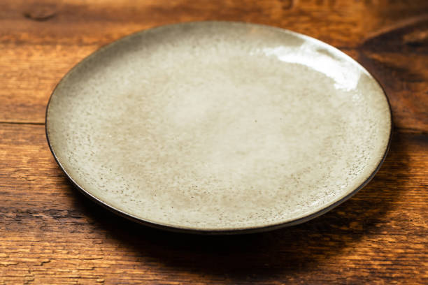 istock empty clay plate on dark wooden background 1502876089
