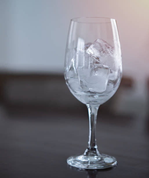 istock Ice cubes in an empty glass wine on a wooden bar counter, soft light background 1502877275