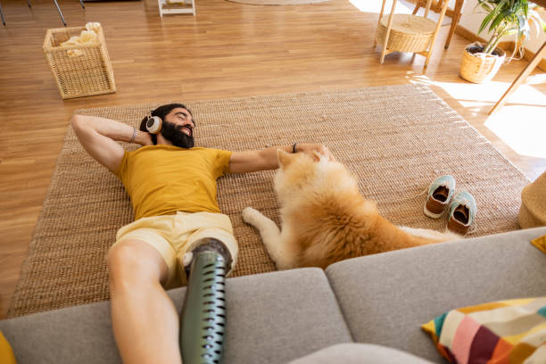 istock man with amputated leg prosthesis, at home with his dog, sitting on carpet and sofa while listening to music 1502877515