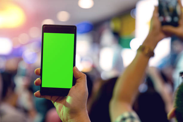 istock Hands holding mobile smartphone with light bokeh in mini concert blur background 1502878594