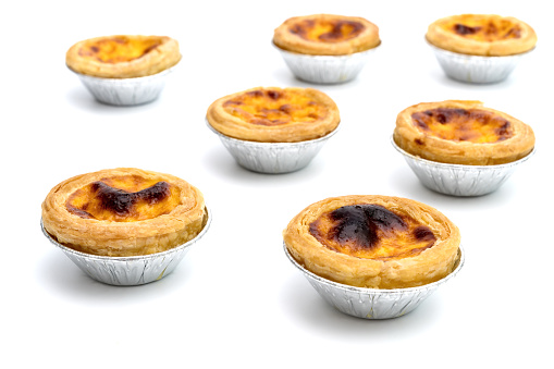 egg tart in aluminum foil cup isolated on white background