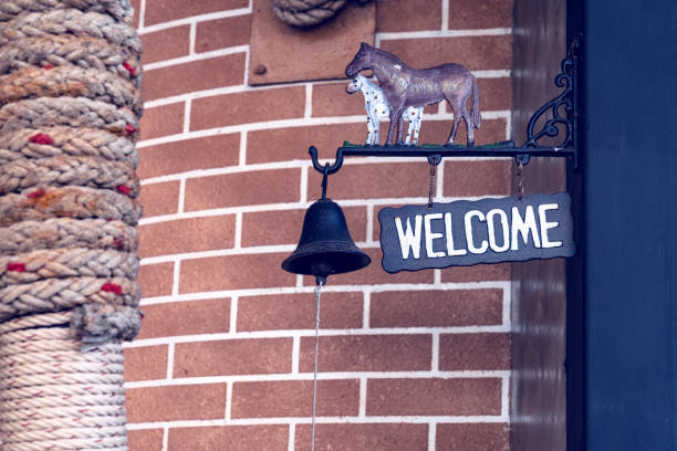 welcome sign with black bell on pole