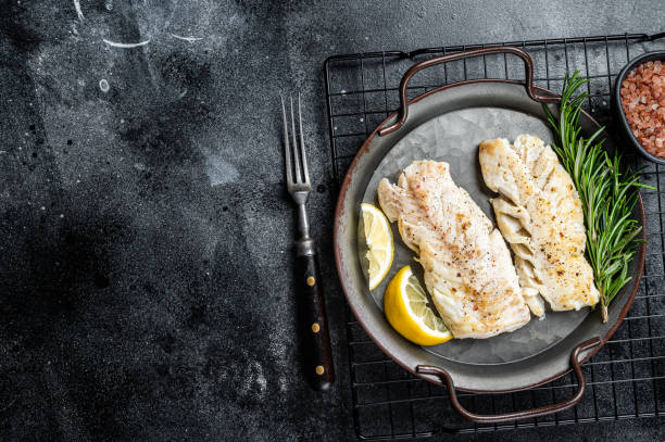 istock Roast Fillets of codfish, cooked cod fish meat. Black background. Top view. Copy space 1502880668