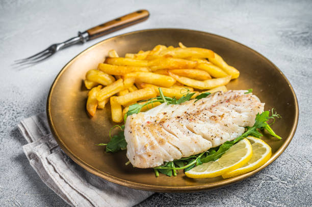 istock Fried cod fish fillet served with french fries. White background. Top view 1502880818