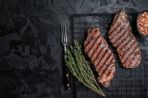 istock Grilled denver beef meat steak on a rack. Black background. Top view. Copy space 1502881513
