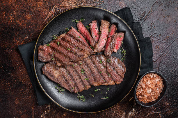 bistecca di carne di manzo di denver striscia di barbecue su un piatto. sfondo scuro. vista dall'alto - strip steak immagine foto e immagini stock
