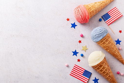 Border with Patriotic ice cream cones with American flag on gray background, Red, white and blue ice cream for 4th of July flat lay, top view