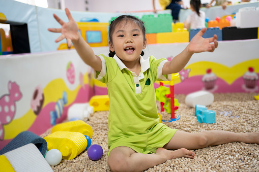 Cute little asian girl entertaining in children playground