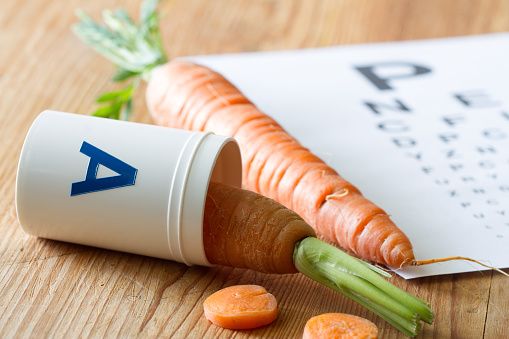 Carrot in vial of vitamin A, natural health for eyesight, concept background