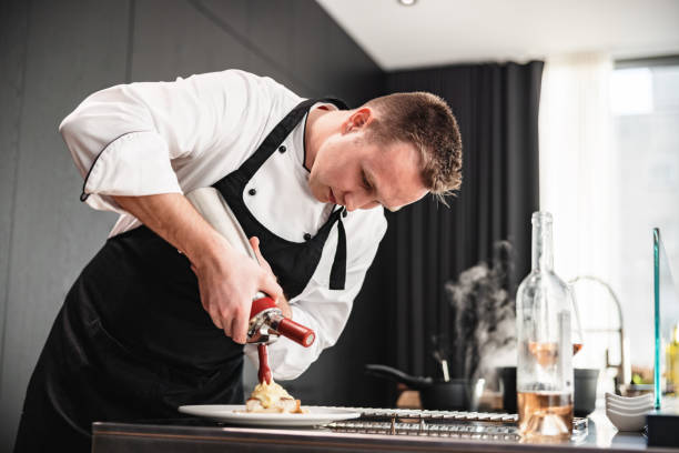 istock Attractive Blonde Professional Private Chef Plating A Dessert In A Modern Kitchen 1502884901