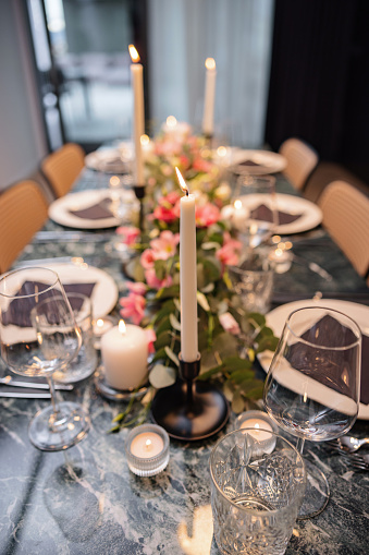 Beautifully decorated table ready for a dinner party. The table is full of beautiful flower arrangements and candles.