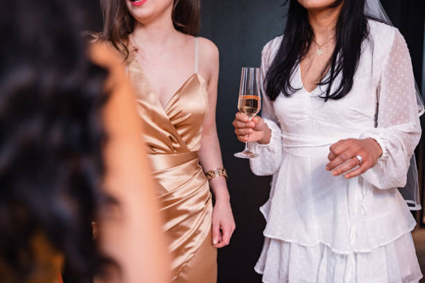 primo piano di una futura sposa che tiene un bicchiere di champagne durante la sua festa di addio al nubilato - champagne wedding luxury dinner foto e immagini stock