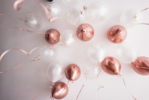 Pink and white balloons covering the ceiling of a hotel bedroom before a celebration. Cute bachelorette decorations.