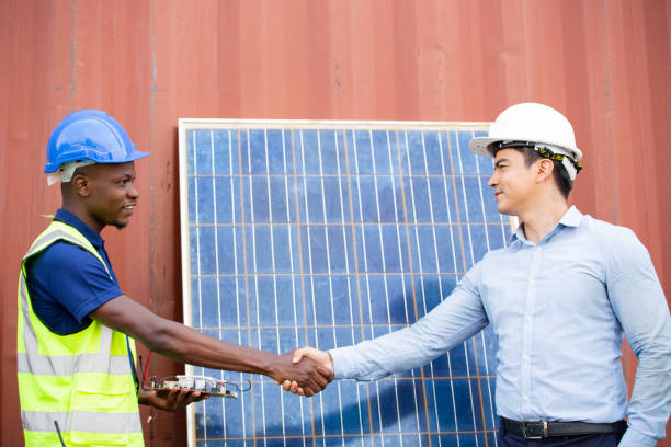 istock Engineer worker and customer hand shaking for agreement collaboration at solar cell farm energy. Dealing and discussing project at construction site 1502885419