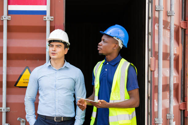 istock Logistic foreman discussing business work with African contractor worker at container warehouse or construction site. 1502885444