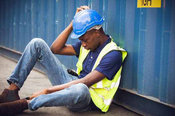 istock African American worker and resting sit at container box at construction site. Contractor or builder man tired and exhausted from work. 1502885561