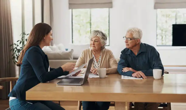 Photo of Senior couple, meeting and investment with a financial advisor, lawyer or woman consulting on a contract, loan or deal. Signature, documents and people with a mortgage, debt or saving in retirement