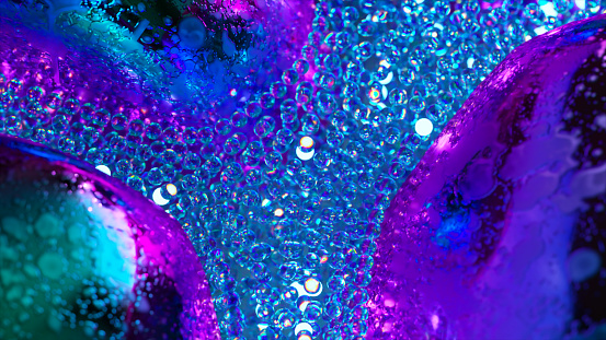 Abstract concept. A stream of glowing blue neon particles flows around gray metal bubbles. Close-up. Advertising. High quality 3d illustration