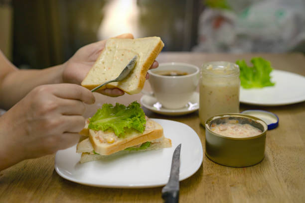 istock hands spreading tuna mayonnaise on bread for breakfast,Cooking sandwich 1502893328