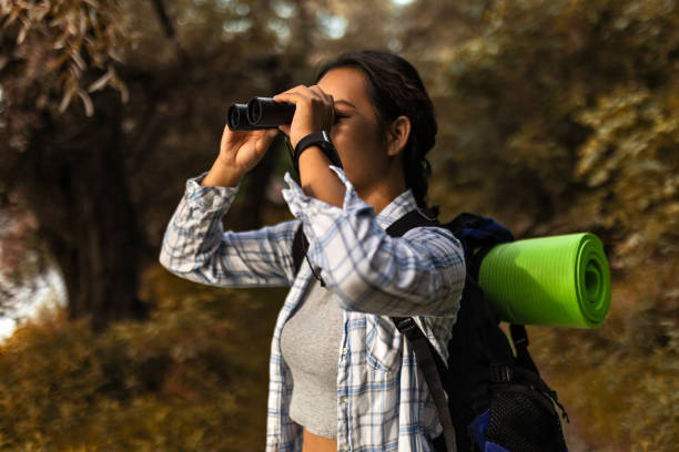 istock Asian woman hiking looking through binoculars 1502893560