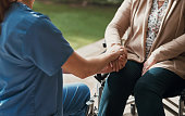 Nurse, holding hands and senior woman in wheelchair with help or support for health or wellness. Elderly patient person with disability and caregiver together for healthcare, kindness or medical care