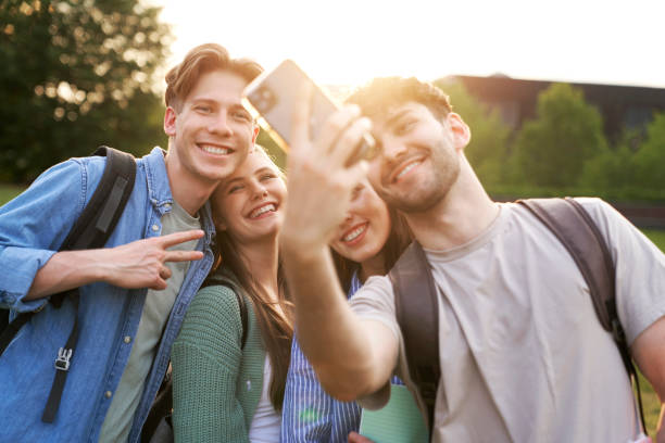 Group of caucasian students taking selfie outside the university campus stock photo