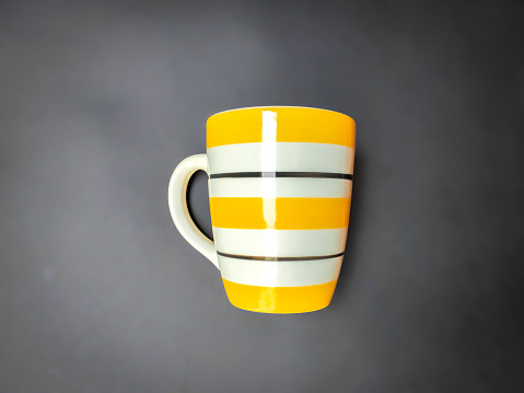 Yellow and black stripe mug on gray background.