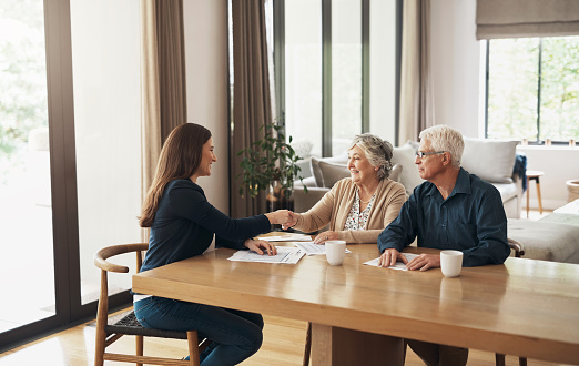 Handshake, broker or happy old couple consulting in meeting for retirement pension or tax bill advice. Financial advisor, elderly man or senior woman shaking hands for investment deal or savings plan