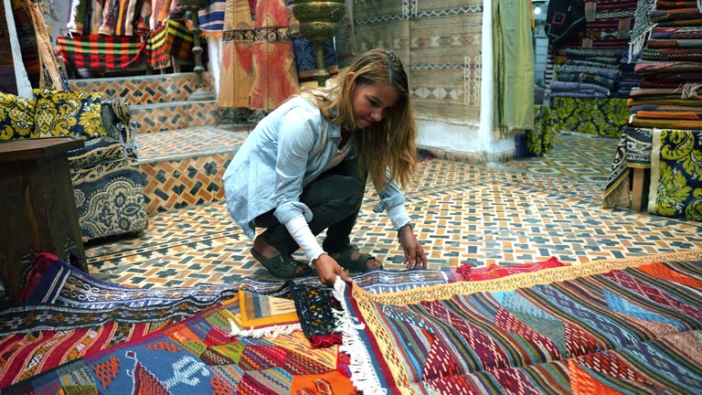 Blond woman shopping at a traditional market for a souvenir rug